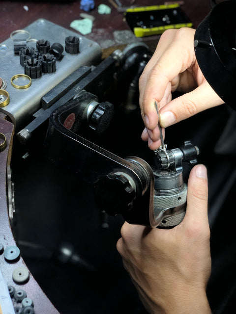 Setting diamonds on a ring.