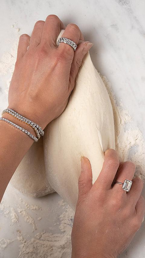 Emerald solitaire ring and radiant eternity band with three tennis bracelet playing with dough.